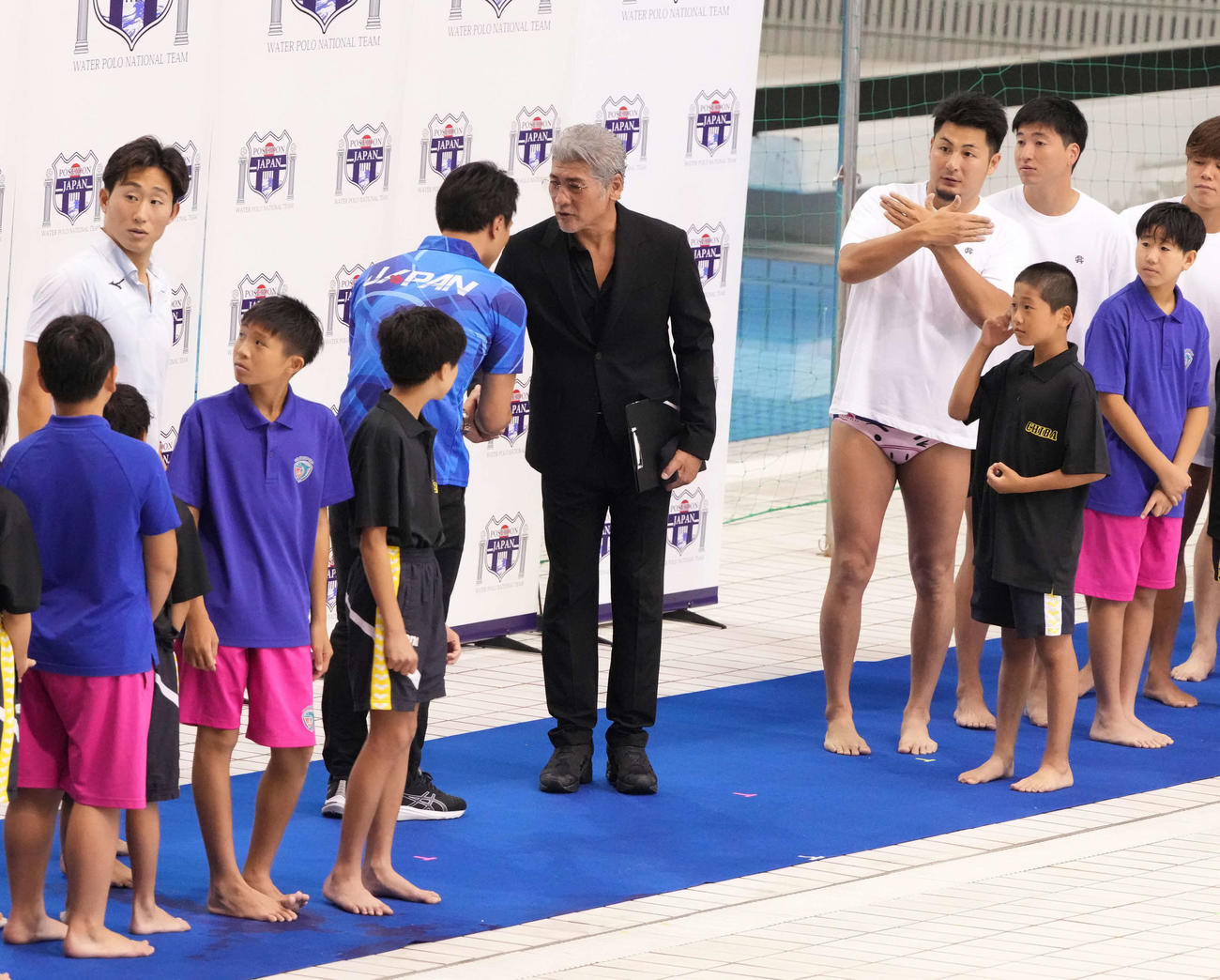 パリ五輪水球男子日本代表壮行会でドリームチームを率いた監督の吉川晃司（中央）は日本代表の塩田監督と握手する（撮影・小沢裕）