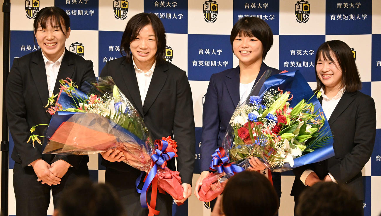 家族から花束を贈られ笑顔を見せる元木咲良（左から2人目）と桜井つぐみ（同3人目）（撮影・飯岡大暉）