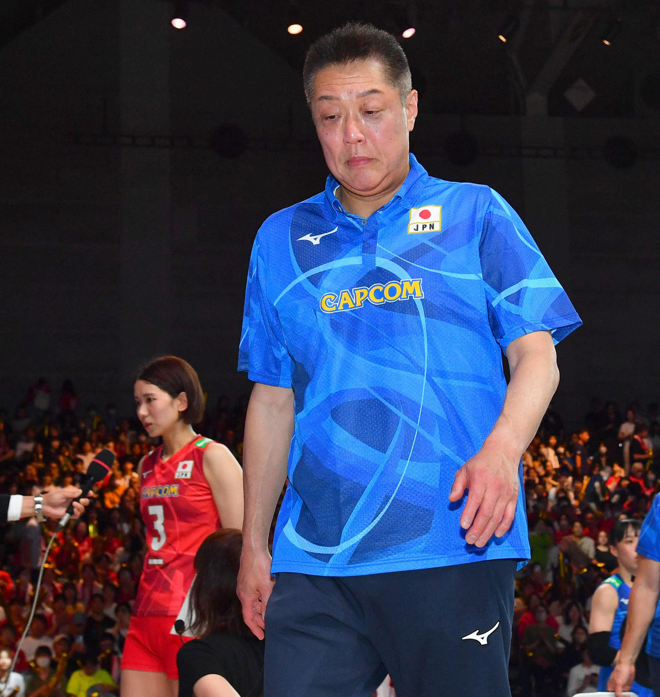 日本対アメリカ　アメリカに敗れ、厳しい表情で引き揚げる真鍋監督。左はインタビューを受ける古賀（撮影・岩下翔太）