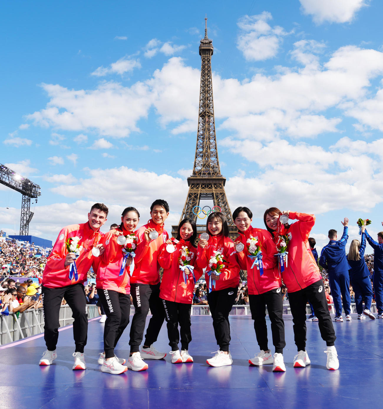 フランス・パリで北京五輪フィギュアスケート団体のメダル授与式に臨み、エッフェル塔を背に写真に納まる日本の選手たち。左から小松原尊、小松原美里、木原龍一、三浦璃来、坂本花織、鍵山優真、樋口新葉（撮影・江口和貴）
