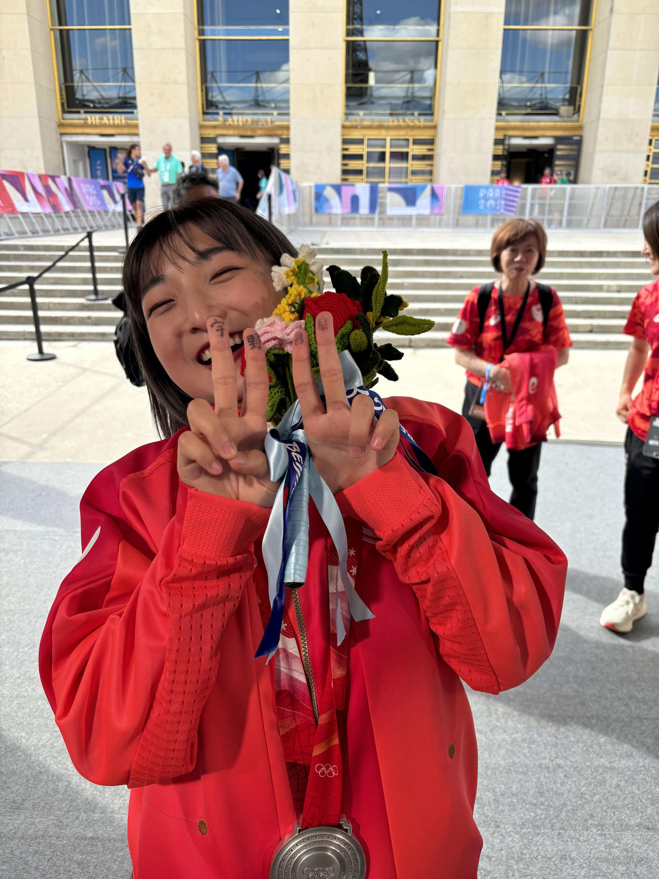 北京五輪団体のメダル授与式で、欠席となった宇野昌磨さんの名前を指に記した坂本花織