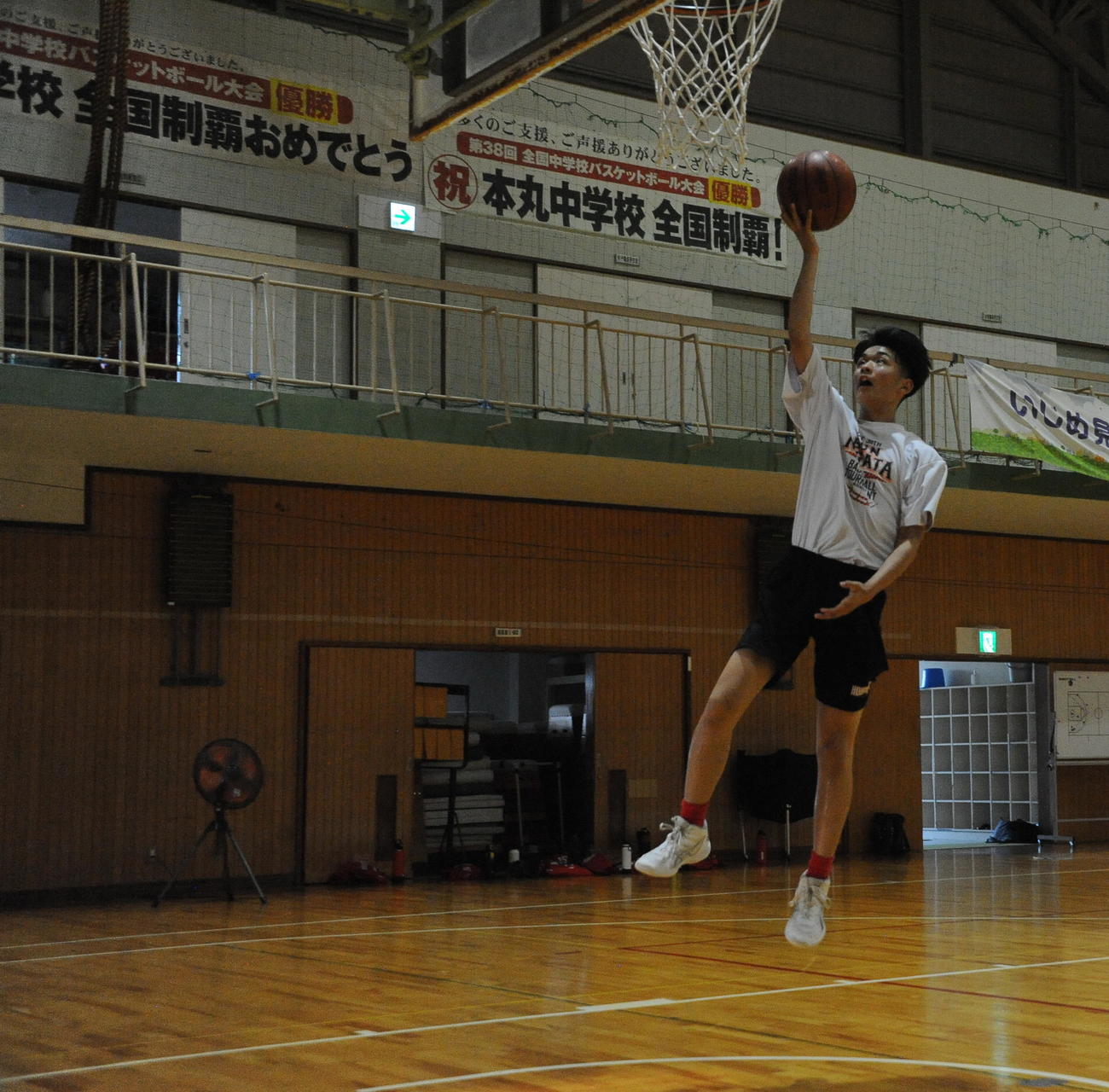 過去2度の全国優勝横断幕が掲げられている体育館で練習する本丸中の男子部員たち（撮影・小林忠）