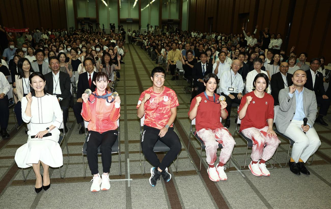 パリ五輪チームニッセイ報告会で写真に納まる、手前左から1人おいて、早田、桐生、出口クリスタ、出口ケリー。左は馬場アナウンサー、右はハナコの岡部大（撮影・河田真司）