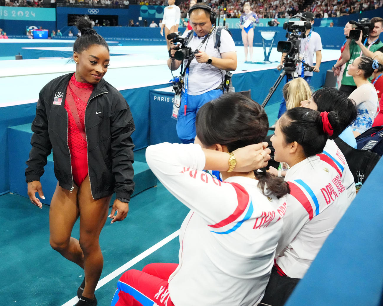 パリ五輪体操女子の種目別跳馬決勝、北朝鮮のアン・チャンオク（右手前から2人目）と目を合わせる米国のバイルス（2024年8月撮影）