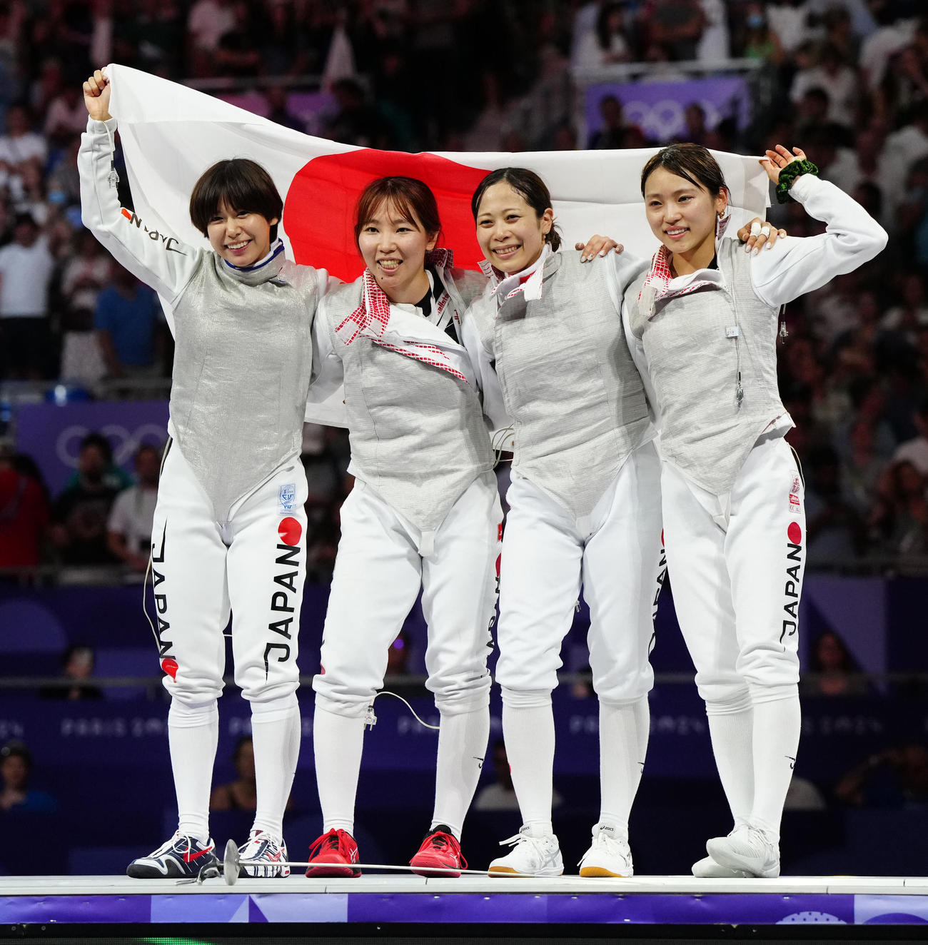フェンシング女子フルーレ団体　カナダとの3位決定戦に勝利し、日の丸を掲げる選手たち。左から宮脇、上野、菊池、東（2024年8月1日撮影）