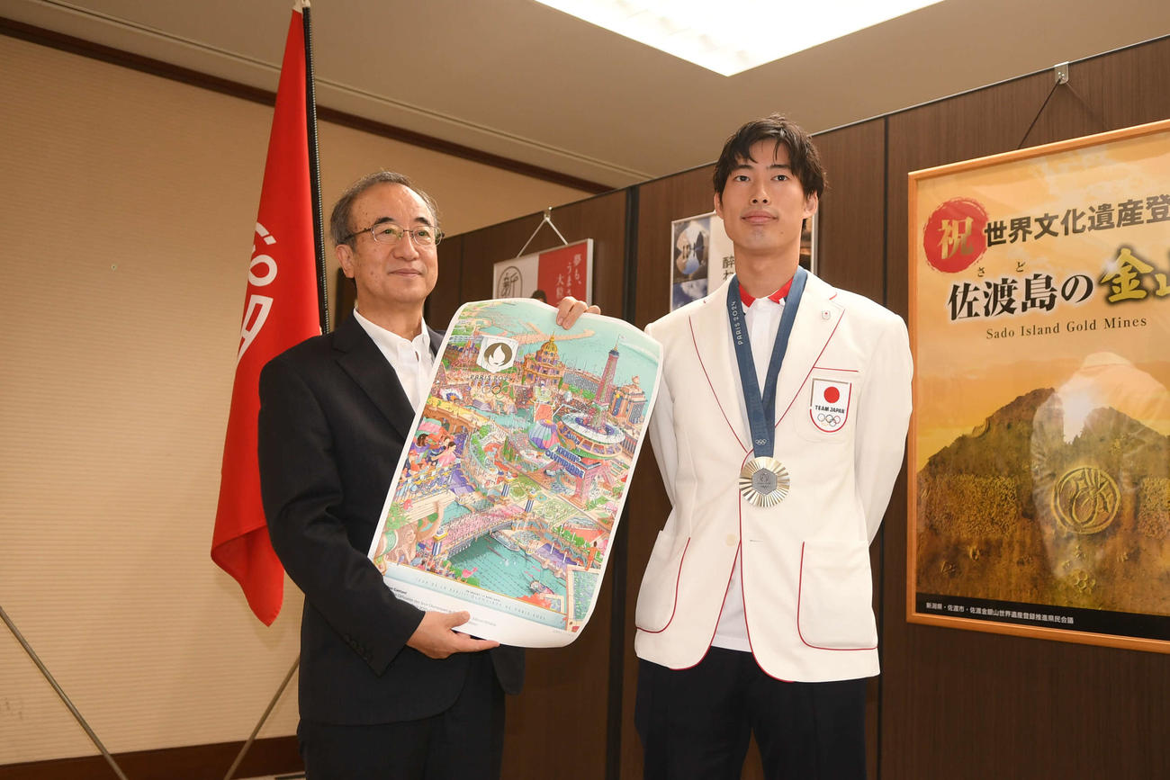 メダリスト用のポスターを手した花角知事（左）と記念撮影をする古俣