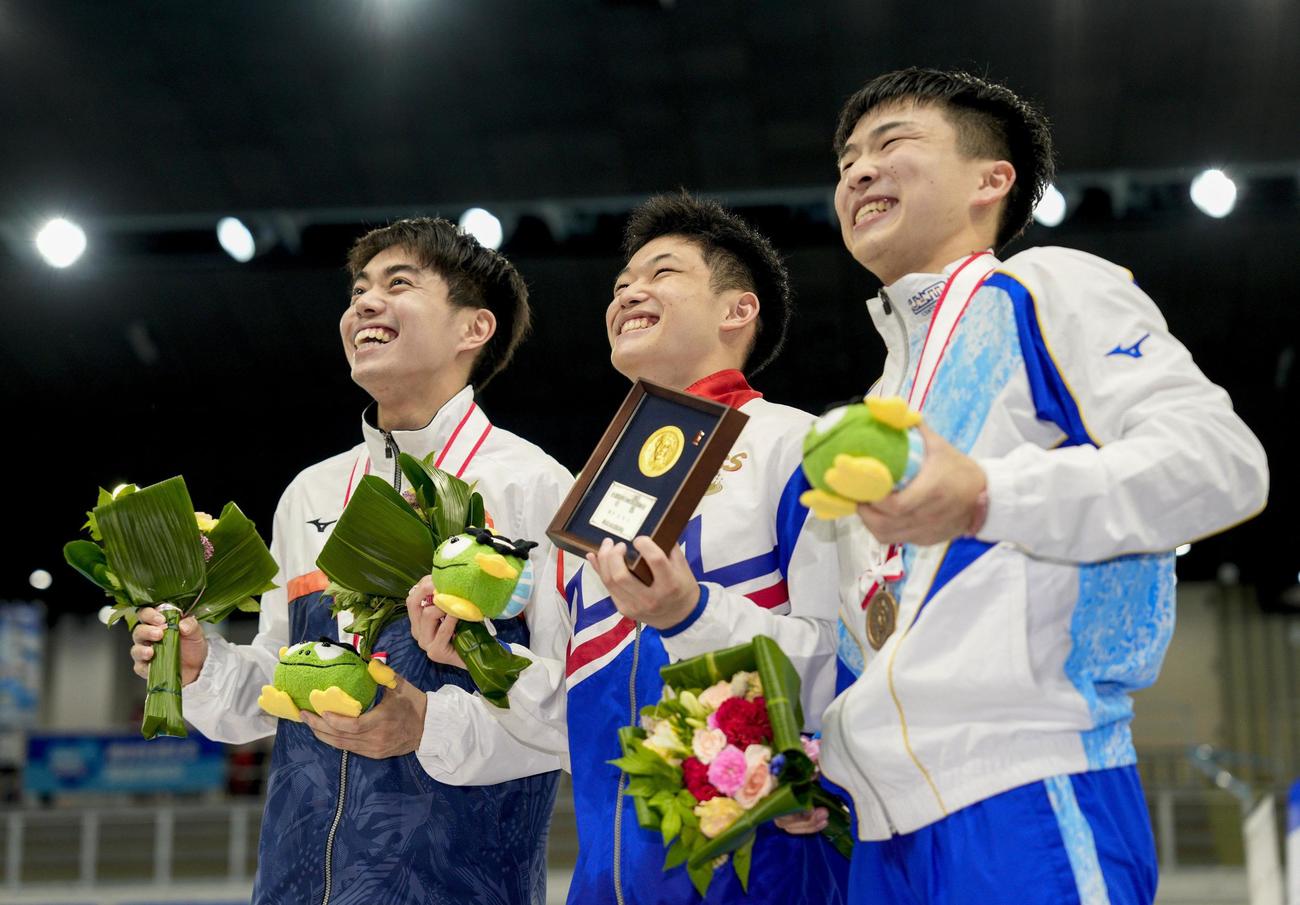 優勝し笑顔の玉井陸斗。左は2位の西田玲雄、右は3位の金戸快（共同）