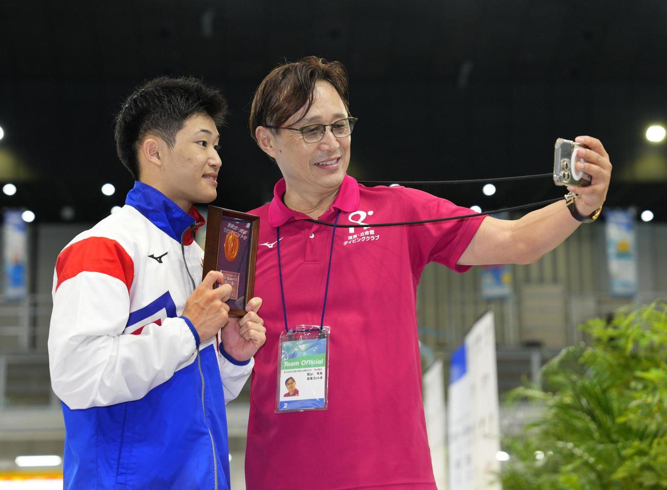 男子高飛び込みで優勝し、馬淵崇英コーチ（右）と記念写真に納まる玉井陸斗（共同）