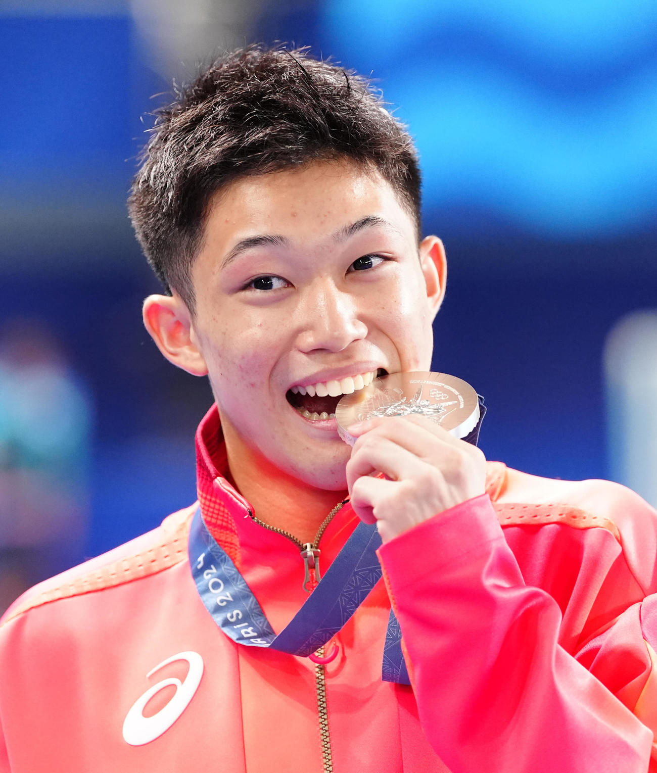 パリ五輪　男子高飛び込み表彰式　銀メダルをかむ玉井陸斗（2024年8月10日撮影）