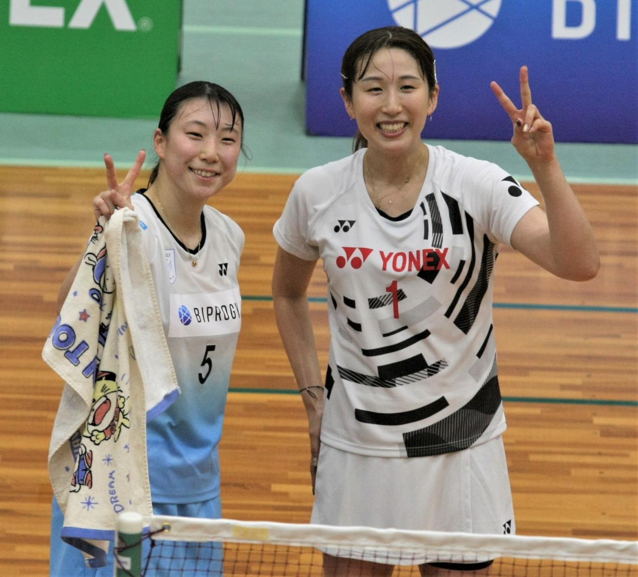 女子ダブルスの試合後に笑顔でピースサインの五十嵐（左）と桜本（撮影・藤塚大輔）