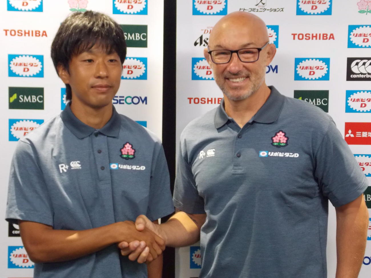 男子7人制日本代表のヘッドコーチに就任したフィル・グリーニング氏（右）は梅田紘一ディレクターと握手する（撮影・松本航）