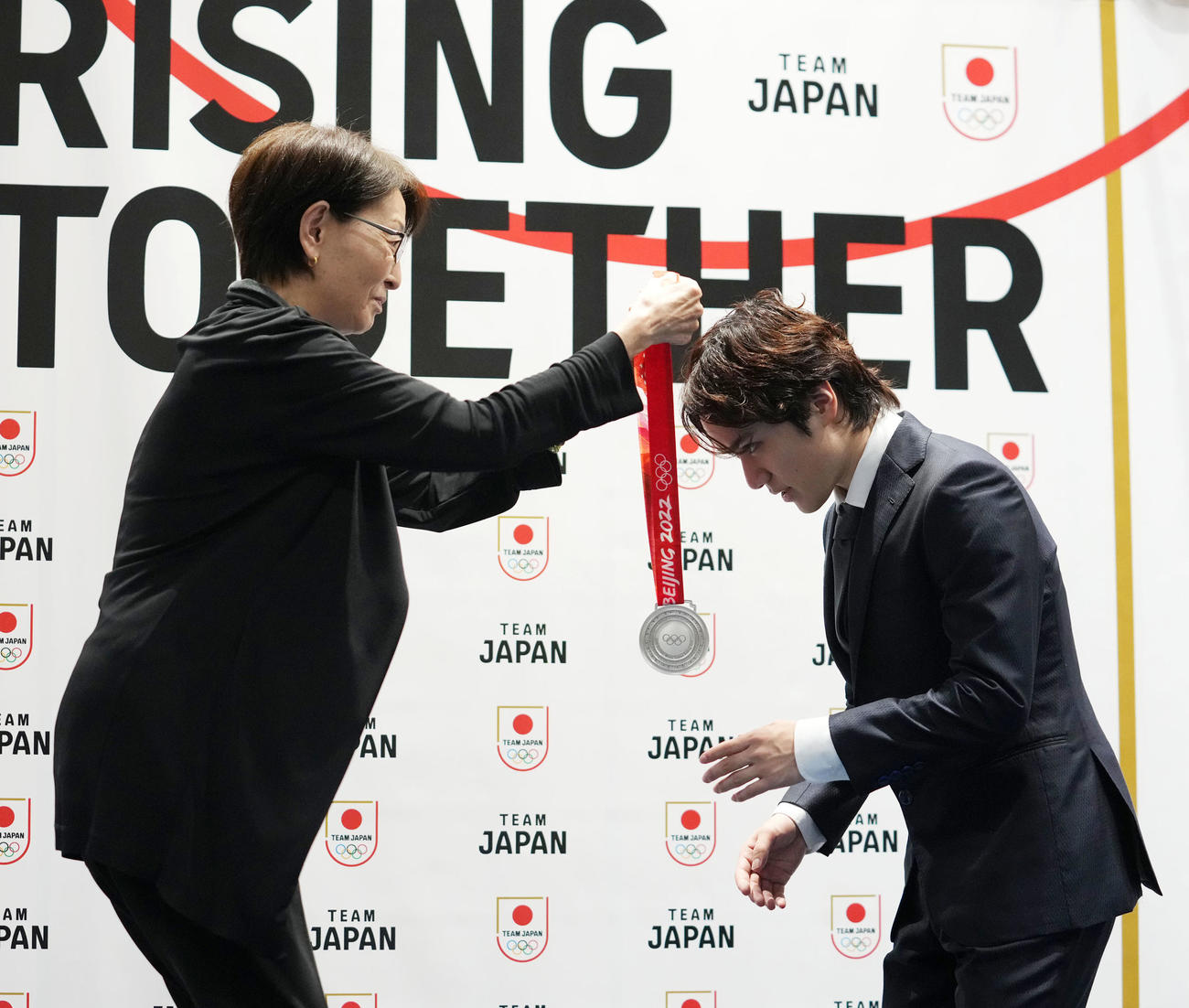 三屋JOC副会長（左）から北京五輪団体での銀メダルを首にかけられる宇野さん（撮影・横山健太）