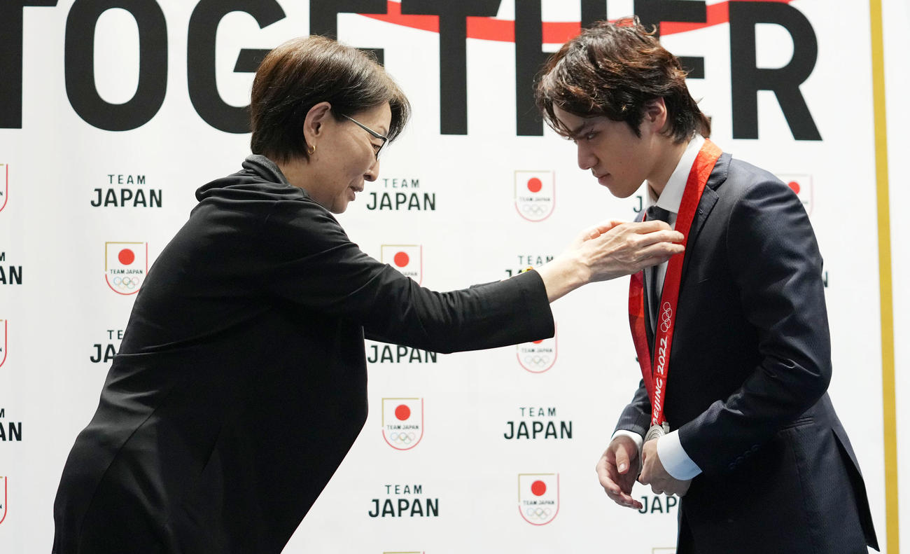 三屋裕子JOC副会長（左）から北京五輪団体での銀メダルを首にかけられる宇野昌磨さん（撮影・横山健太）