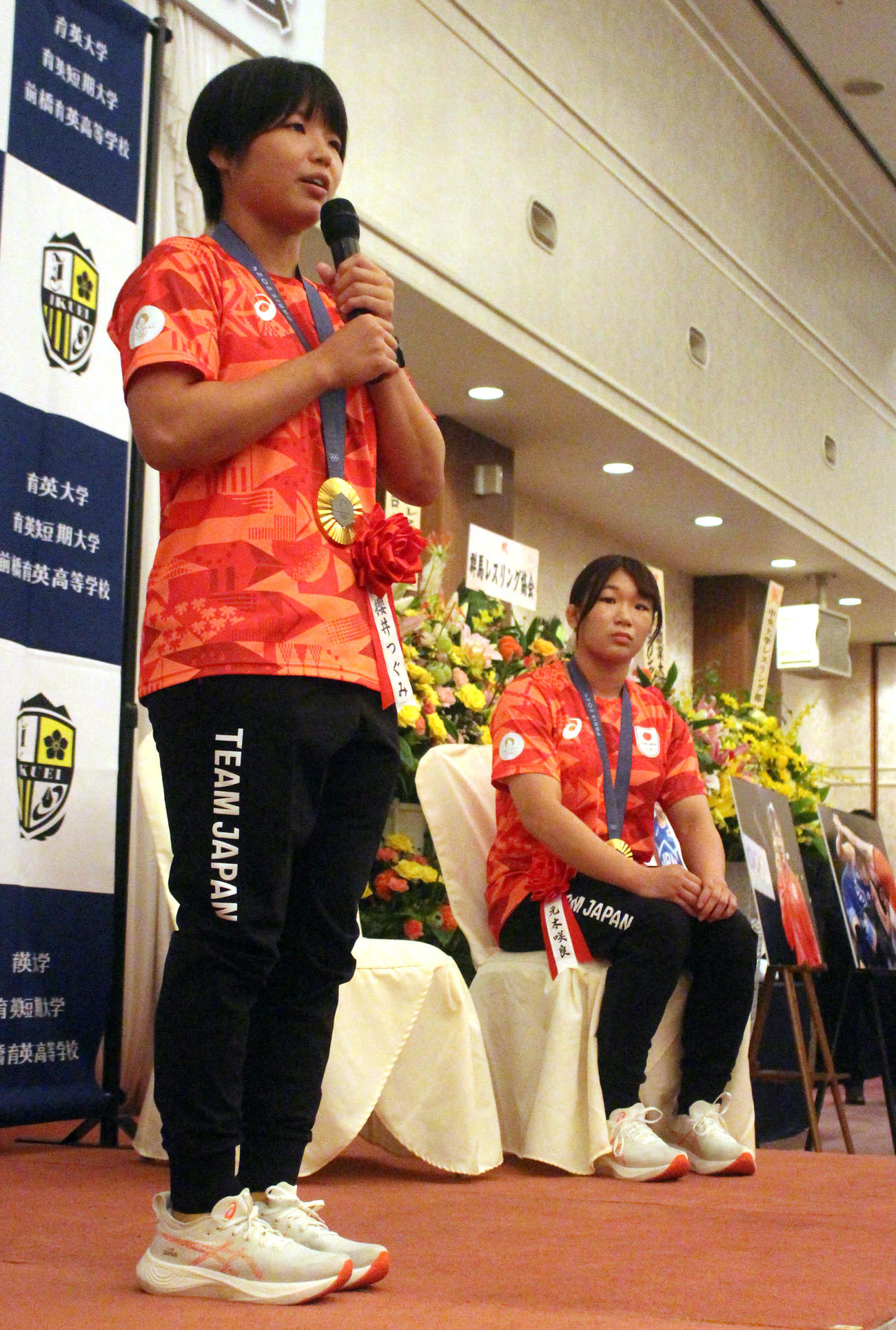 育英大の祝勝会で感謝の言葉を述べるパリ五輪レスリング女子金メダリストの桜井（左）。右は元木