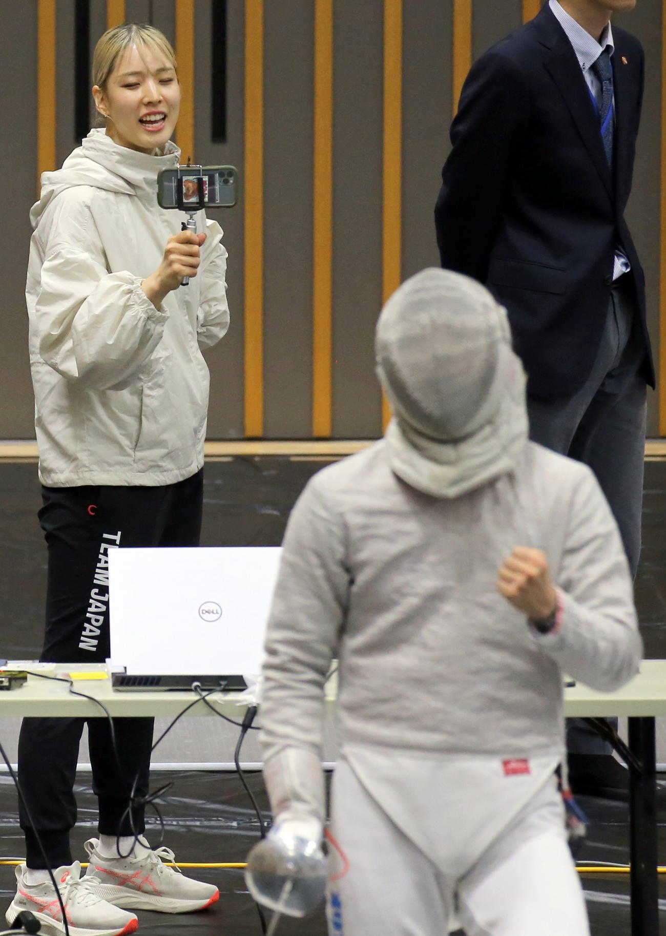 フェンシング全日本選手権　男子サーブル3回戦でポイント獲得を喜ぶ江村凌平（手前）と、試合を撮影するベンチコーチの姉美咲（撮影・木下淳）