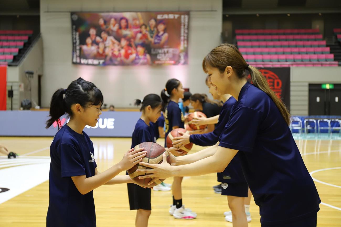 公式試合使用球を小学生に手渡すWリーグの選手たち（モルテン提供）