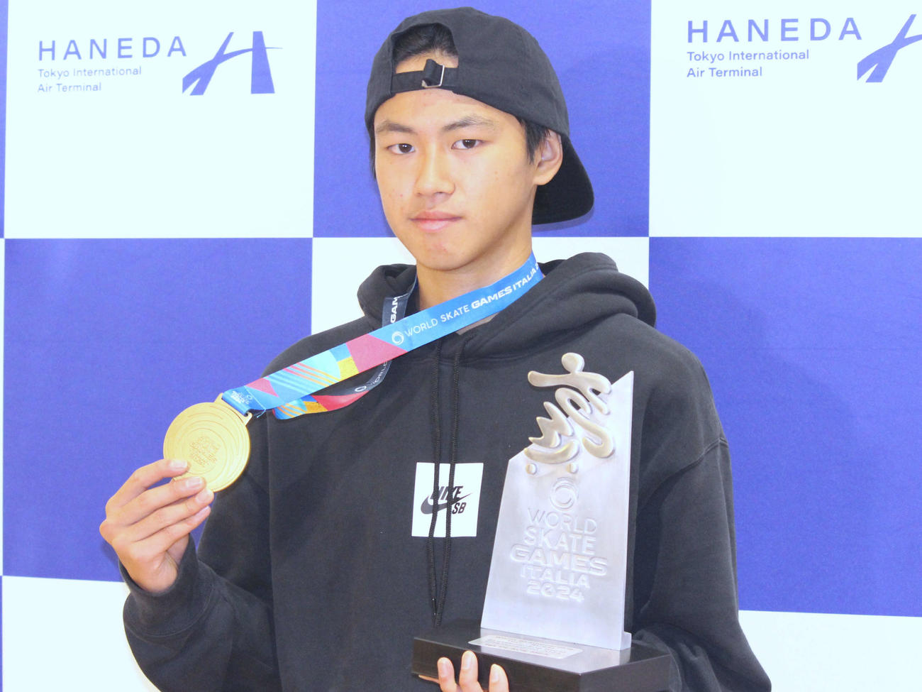 世界選手権の金メダルとトロフィーを手に写真に納まる佐々木（撮影・勝部晃多）