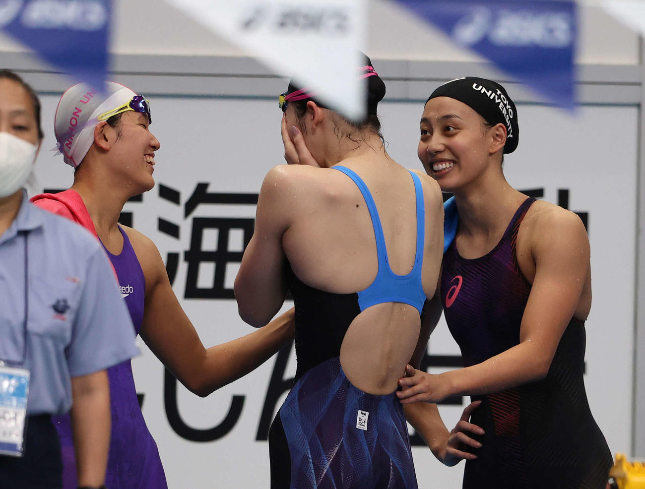 2021年10月9日、競泳日本学生選手権女子400メートルメドレーリレーで予選敗退となり涙を見せる池江（中央）に声をかける今井（右）。左は小堀