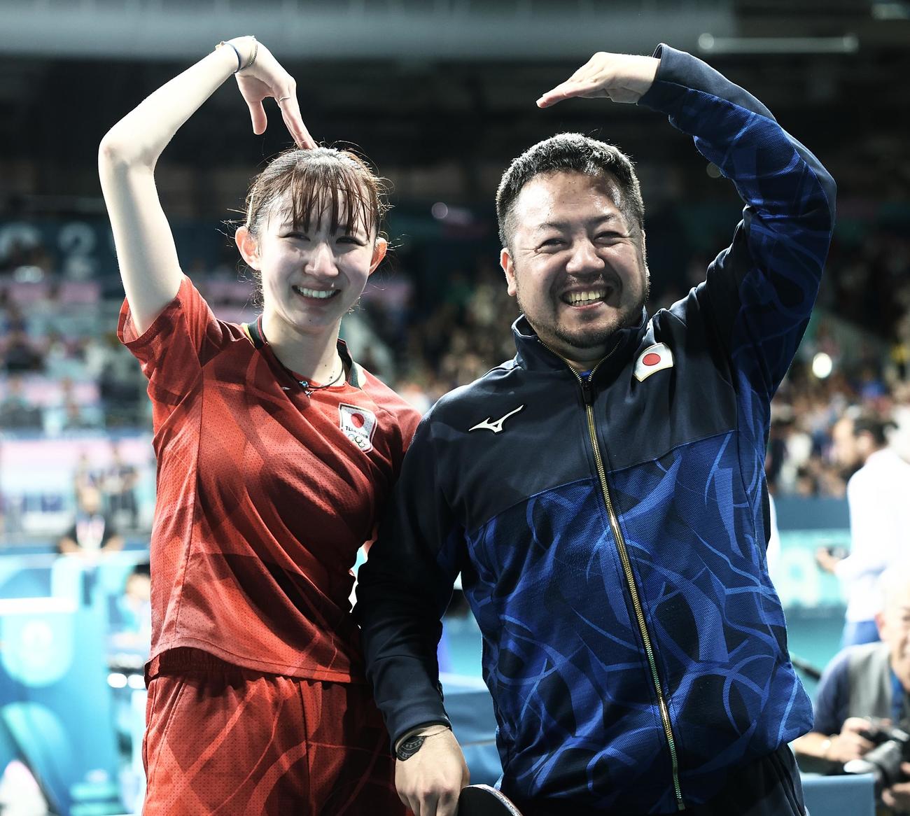 女子シングルス3位決定戦で勝利し銅メダルを決め、ポーズを決め喜ぶ早田（左）と石田コーチ（2024年8月撮影）