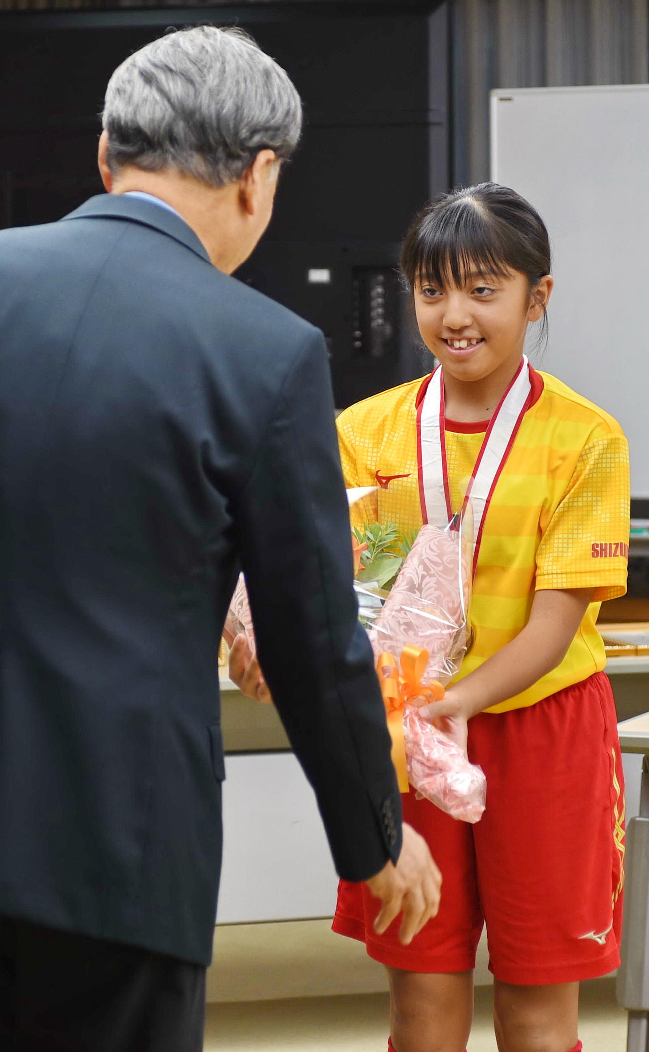 難波市長（左）から代表して花束を受けとるドッキーズの工島主将　