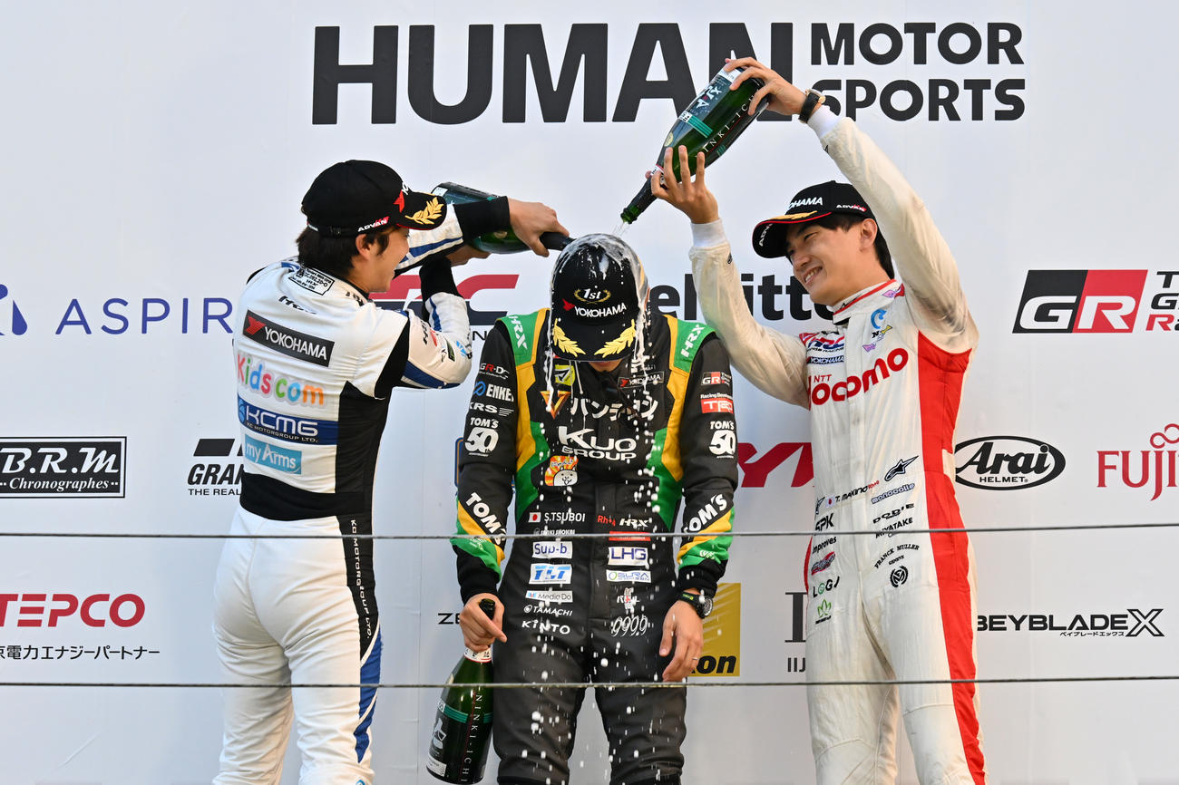 スーパーフォーミュラ第7戦、優勝した坪井翔は、2位の福住仁嶺（左）、3位の牧野任祐（右）からスパークリング大吟醸を掛けられる（JRP提供）