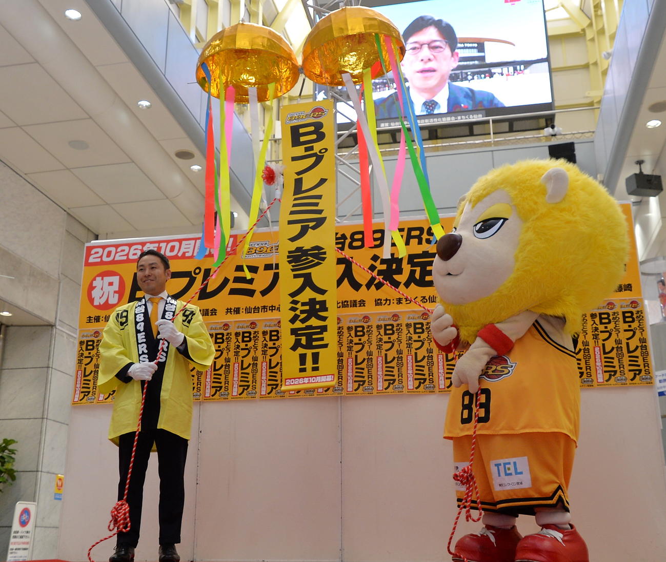 「B.プレミア」参入が決まり、くす玉を割るB1仙台89ERSの志村社長（左）とマスコットの「ティナ」（撮影・浜本神威）