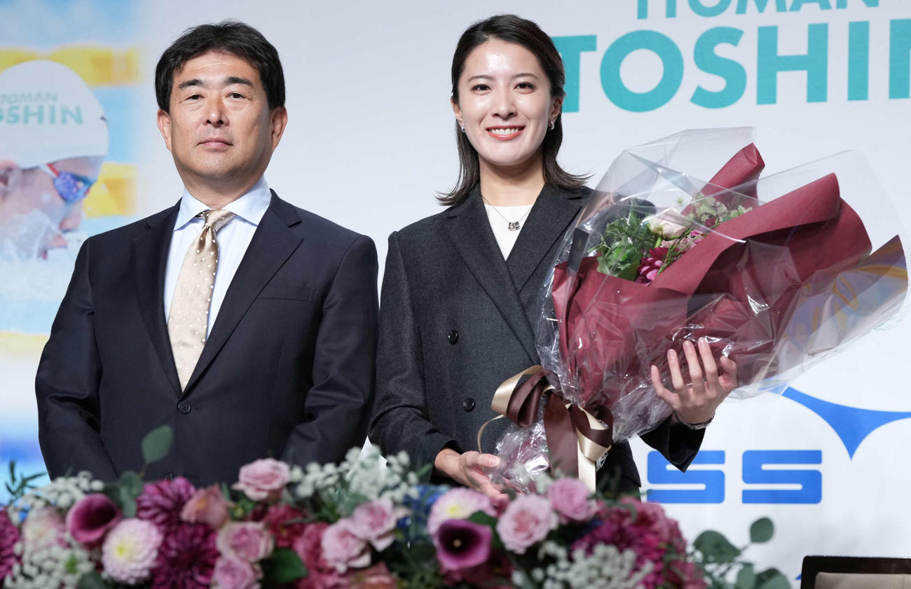 引退会見に臨んだ大橋（右）は元日本代表ヘッドコーチの平井監督から贈呈された花束を手に記念撮影に納まる（撮影・小沢裕）