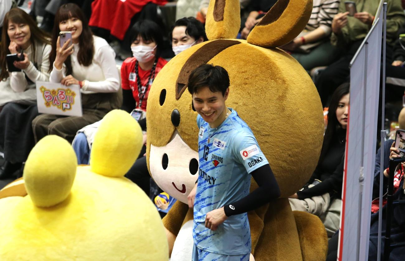 今季リーグ戦初勝利を飾ったサントリーの高橋藍は、MVPの看板の前で敵地旭川のファンに笑顔（撮影・中島洋尚）