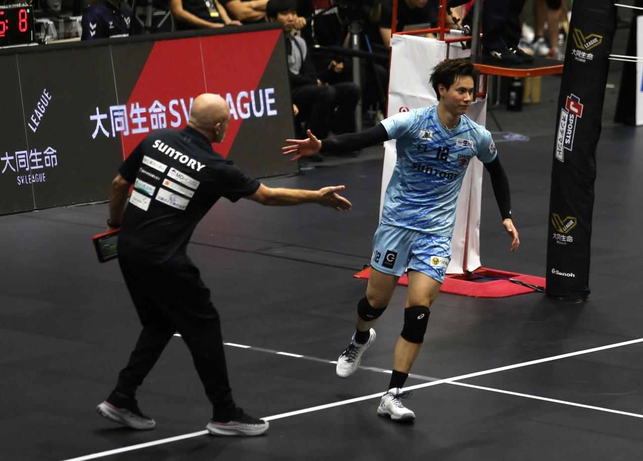 サントリーの高橋藍（右）は、バックアタックを決めて、オリビエ監督とハイタッチ（撮影・中島洋尚）