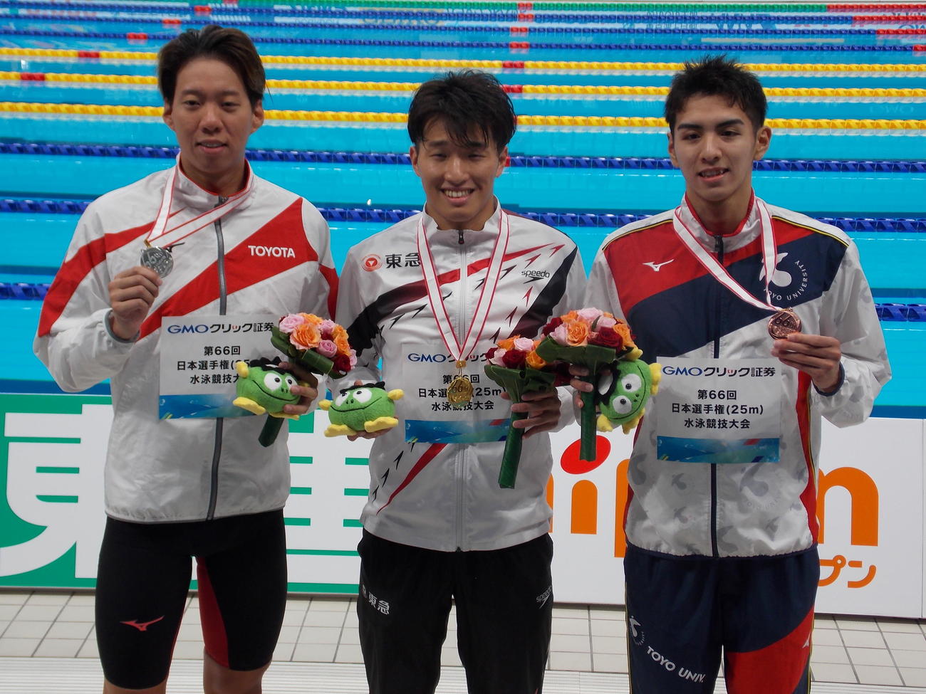 競泳の日本短水路選手権男子200メートル平泳ぎを制した深沢大和（中央）と2位の渡辺一平（左）、3位の牧野航介（撮影・松本航）