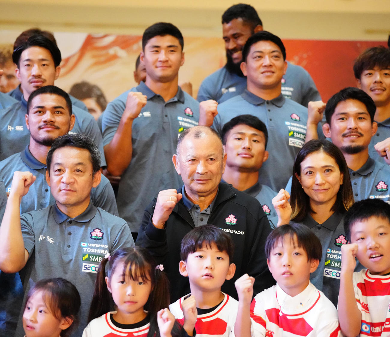 ラグビー日本代表ファンミーティングに臨み、子どもたちと写真に納まるエディー・ジョーンズ・ヘッドコーチ（中央）ら（撮影・江口和貴）