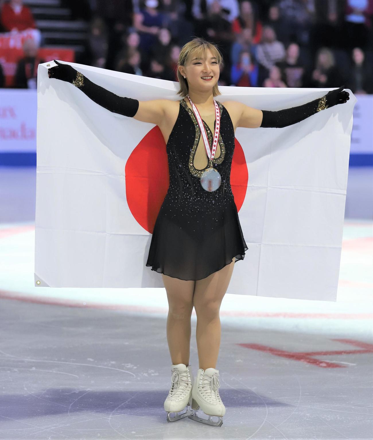 フィギュアスケートGPシリーズスケートカナダ　表彰式で日の丸を掲げる坂本花織（撮影・藤塚大輔）