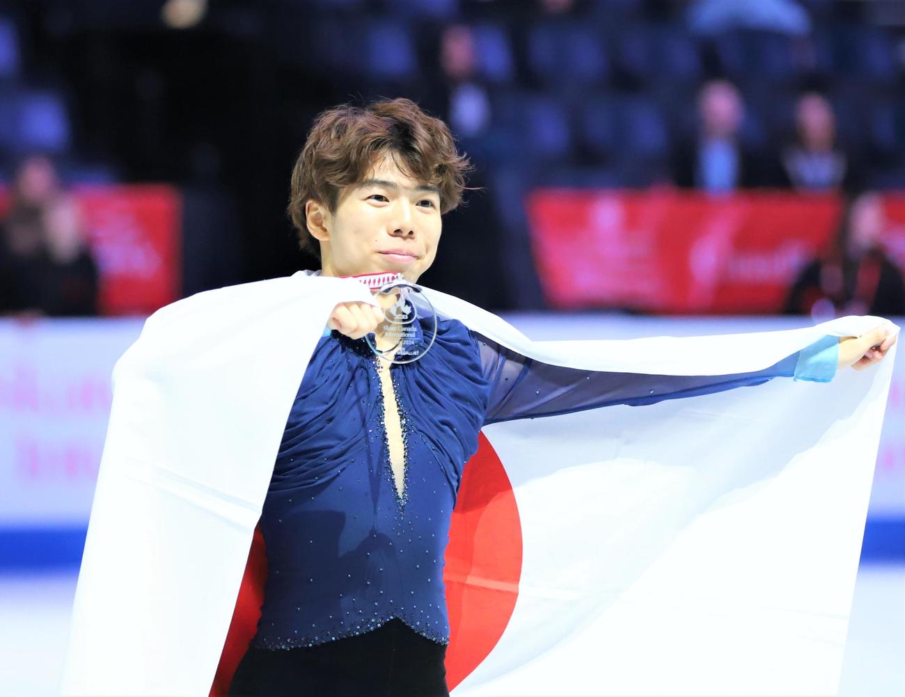 男子表彰式で日の丸を掲げる佐藤駿（撮影・藤塚大輔）