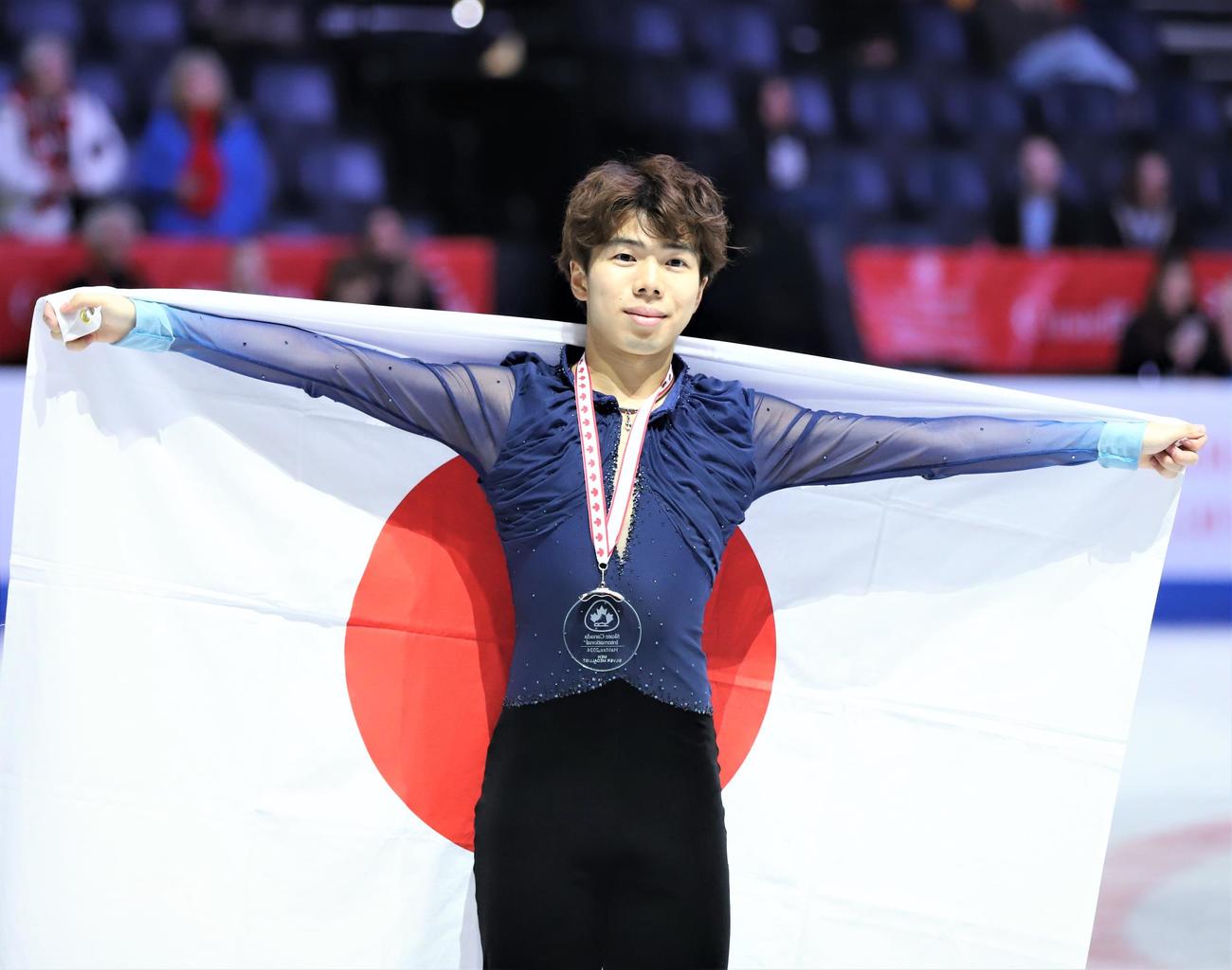 フィギュアスケートGPシリーズスケートカナダ　男子表彰式で日の丸を掲げる佐藤駿（撮影・藤塚大輔）