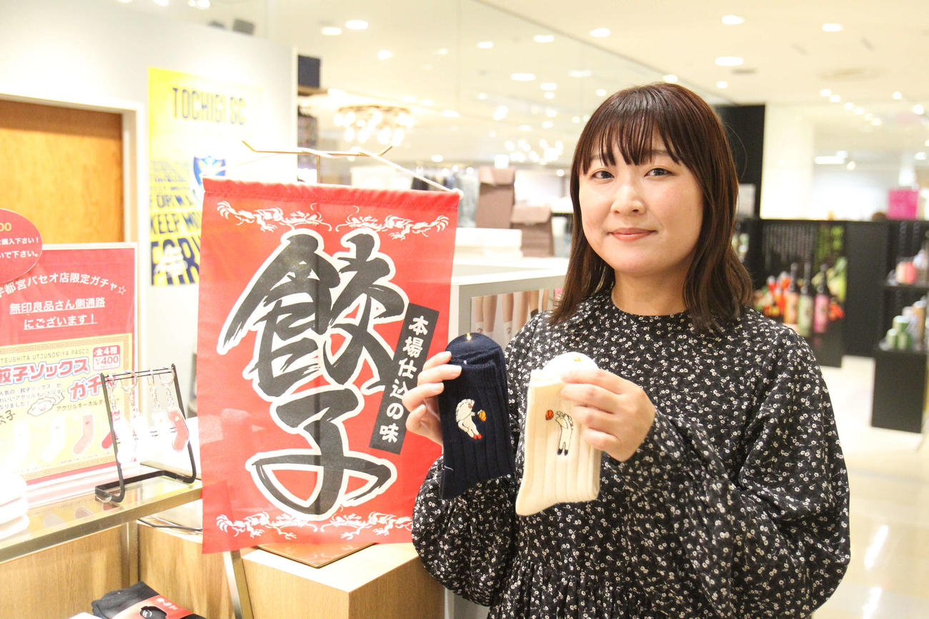 限定発売中の「餃子バスケコラボ」靴下を手にする靴下屋「宇都宮パセオ店」の内田奈津美店長（撮影・沢田啓太郎）