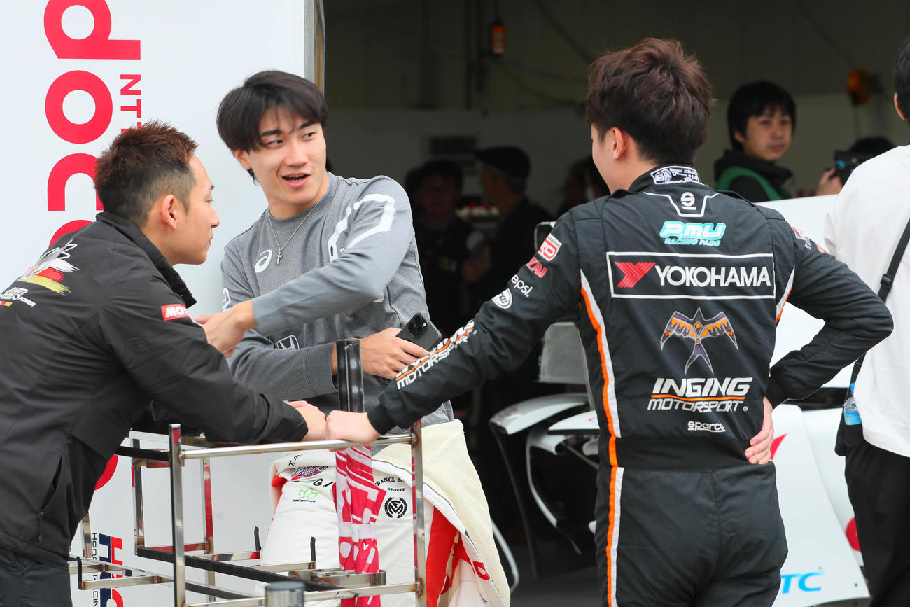 スーパーフォーミュラ第9戦　ピット前で話し合う牧野任祐（中央）と阪口晴南（右）ら（撮影・宮崎幸一）