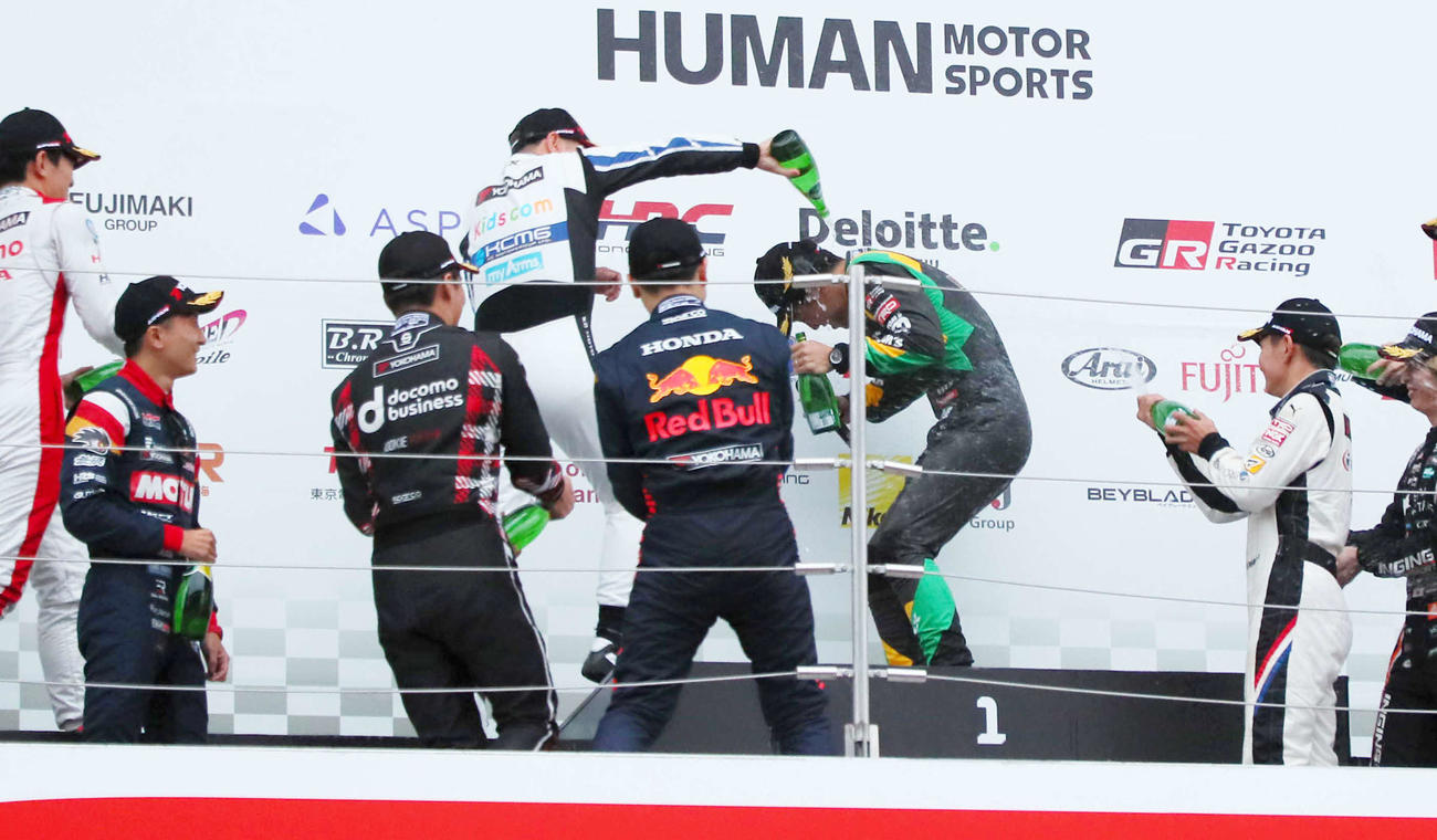 スーパーフォーミュラ最終戦でドライバーズチャンピオンを決めたチームトムスの坪井翔（中央右）は、ドライバー仲間に炭酸水をかけられる（撮影・宮崎幸一）