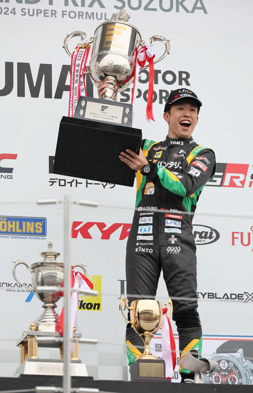スーパーフォーミュラ最終戦でドライバーズチャンピオンを決めたチームトムスの坪井翔は、表彰式でカップを手に笑顔を見せる（撮影・宮崎幸一）