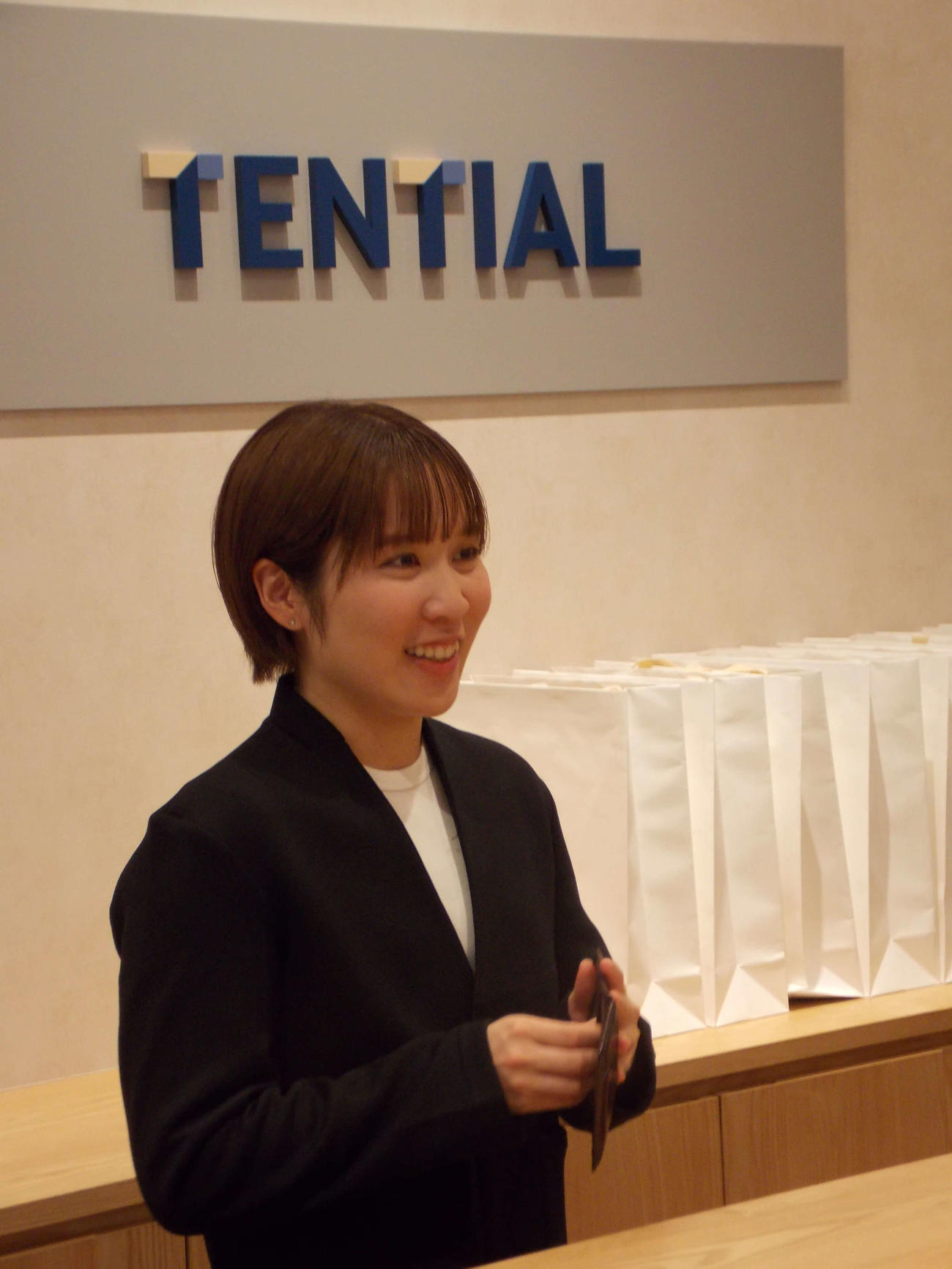 TENTIAL虎ノ門ヒルズ店で一日店長を務めた平野美宇は笑顔で名刺を出す（撮影・松本航）