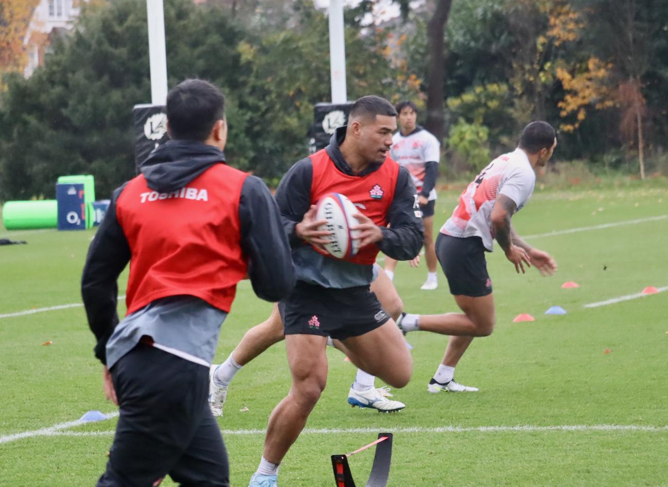イングランド戦に向けての練習でボールを持ちながら走るCTBシオサイア・フィフィタら日本代表（C）JRFU