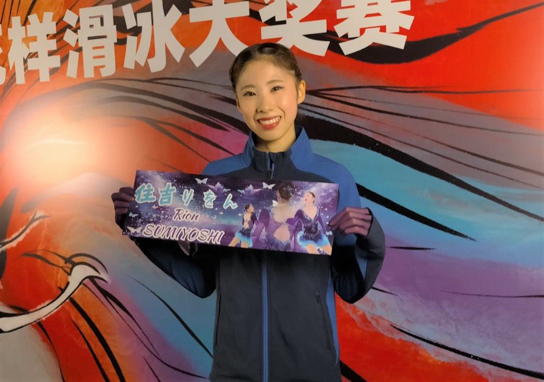 フィギュアスケートGPシリーズ中国杯　女子SPの演技後にバナーを掲げて笑顔を見せる住吉（撮影・阿部健吾）