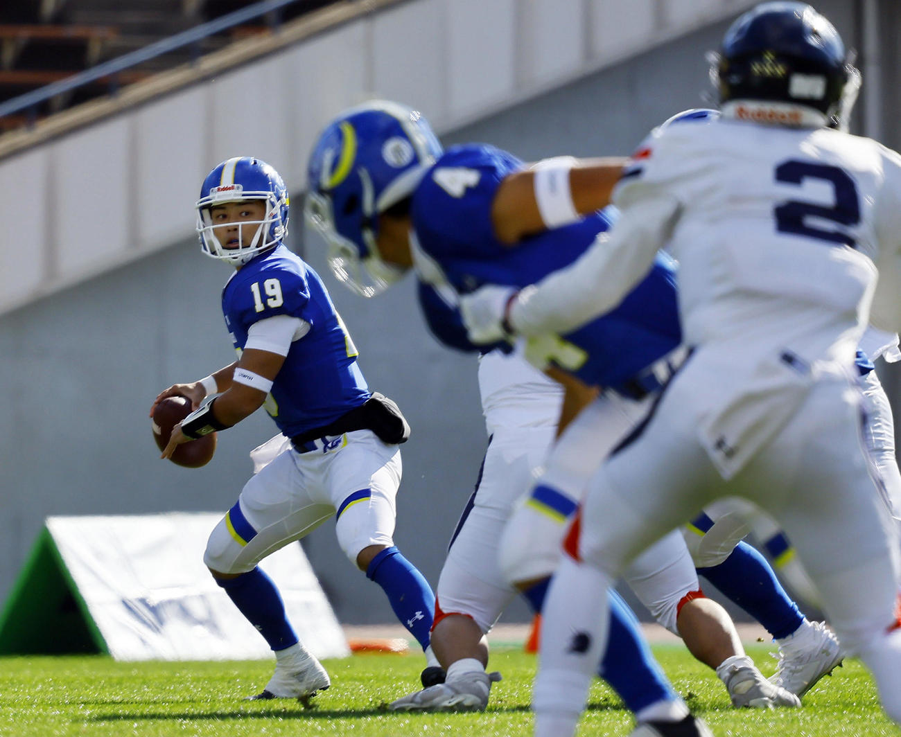 全日本大学アメリカンフットボール選手権・準々決勝　関学大対慶大　第1Q、パスを出す関学大・星野（左端）（撮影・藤尾明華）