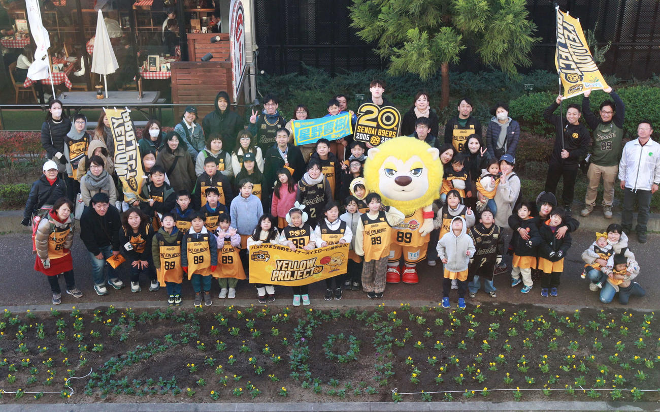 20周年の20が刻まれた花壇の前で記念写真を撮るB1仙台・星野曹樹と参加者たち＝2024年11月24日