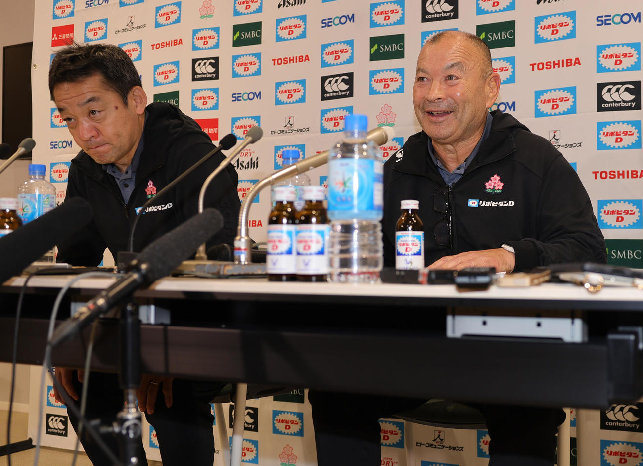 会見を終え、笑顔であいさつするラグビー日本代表ジョーンズヘッドコーチ。左は永友チームディレクター（撮影・野上伸悟）