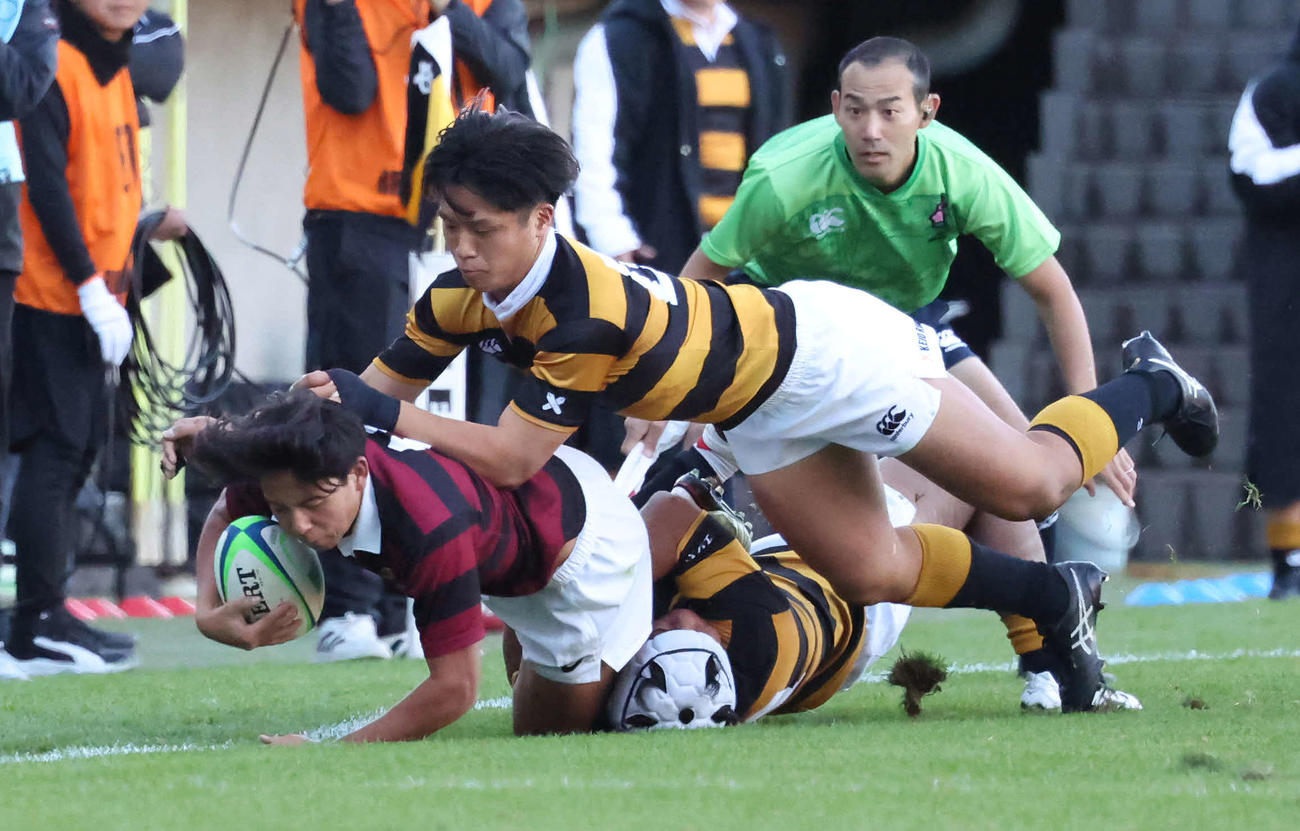11月23日、慶大対早大　早大SO服部（左）をタックルで止める慶大WTB小野沢