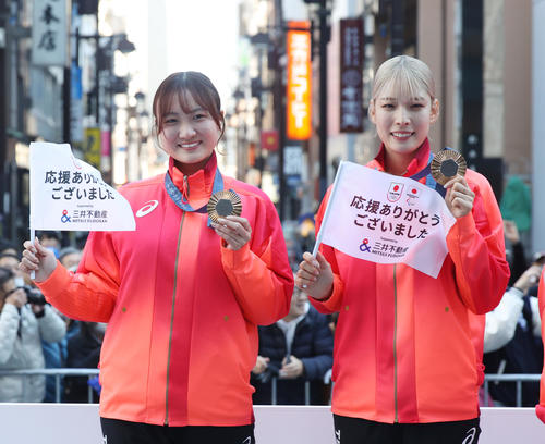 パリ五輪・パラのパレードで撮影に応じるフェンシング女子サーブル団体銅メダルの尾崎（左）と江村（撮影・柴田隆二）