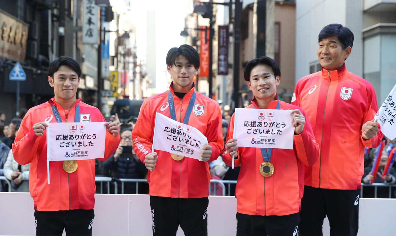 パリ五輪・パラのパレードで撮影に応じる、左から体操の谷川、橋本、萱、尾県JOC団長（撮影・柴田隆二）