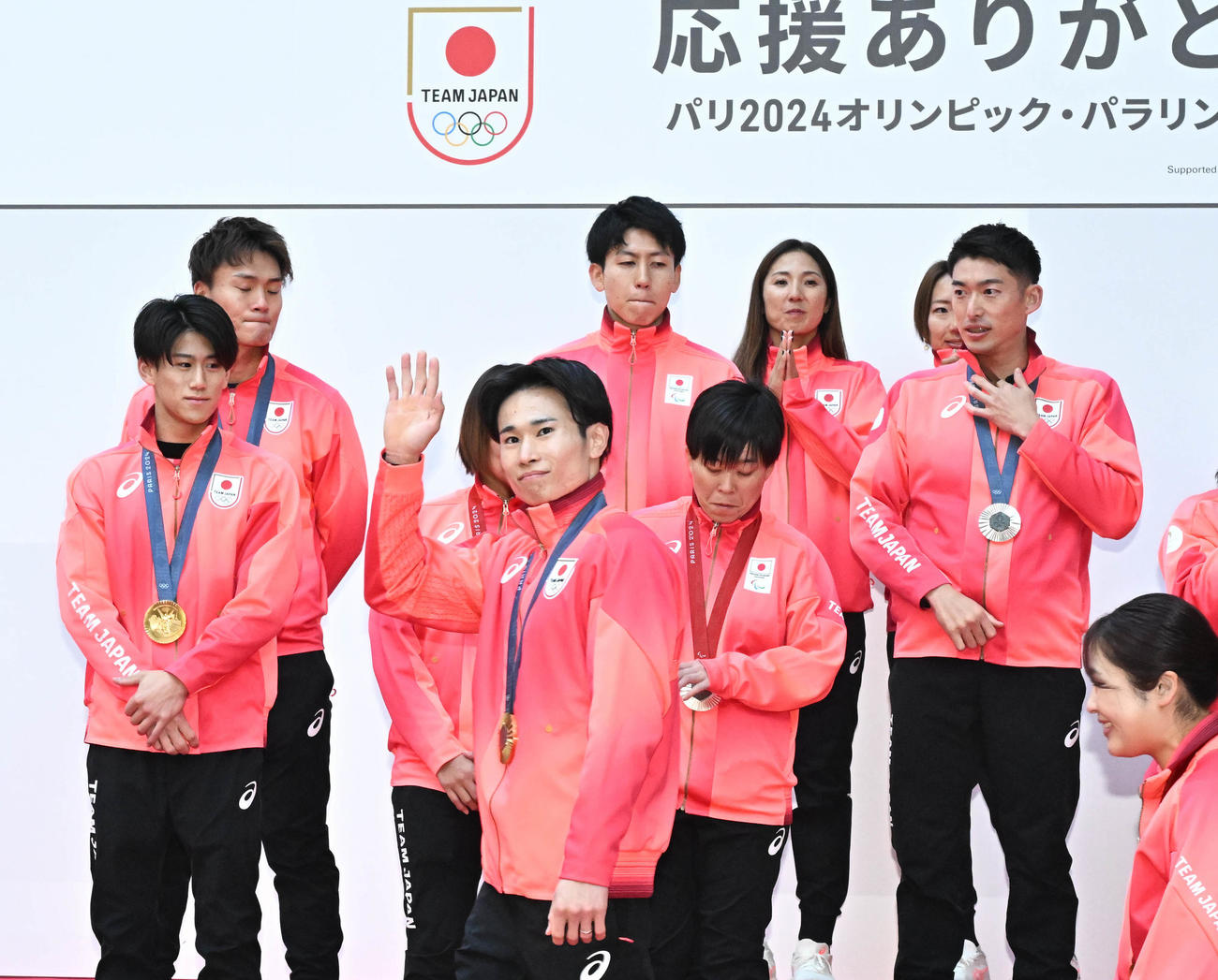 「パリ五輪・パラリンピックTEAM JAPAN応援感謝イベント」のパレードに手を振りながら向かう体操男子団体総合の萱和磨ら（撮影・千葉一成）