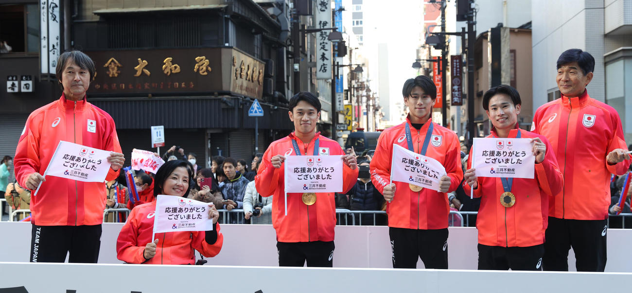 パリ五輪・パラのパレードで撮影に応じる、左から中沢JPC副団長、田口JPC団長、体操の谷川、橋本、萱、尾県JOC団長（撮影・柴田隆二）