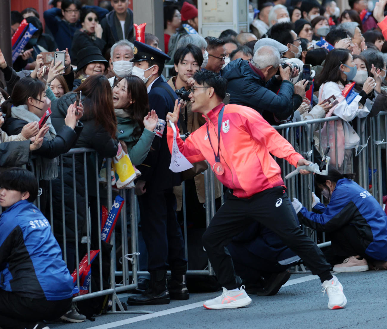 パリ五輪・パラのパレードで観客と記念撮影する男子フリースタイル74キロ級銀メダルの高谷（撮影・柴田隆二）